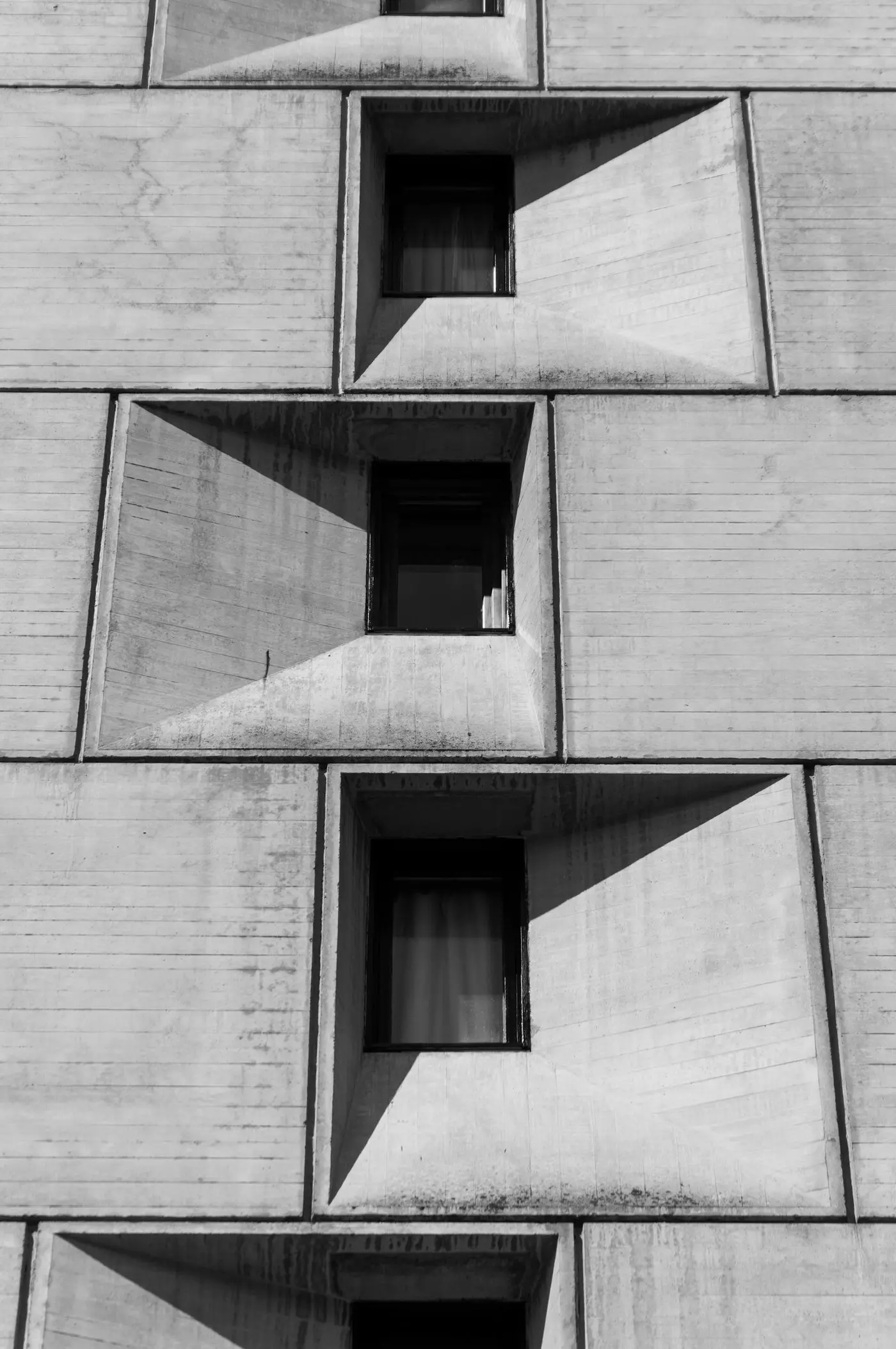 Façade en béton avec fenêtres profondes en encadrements biseautés